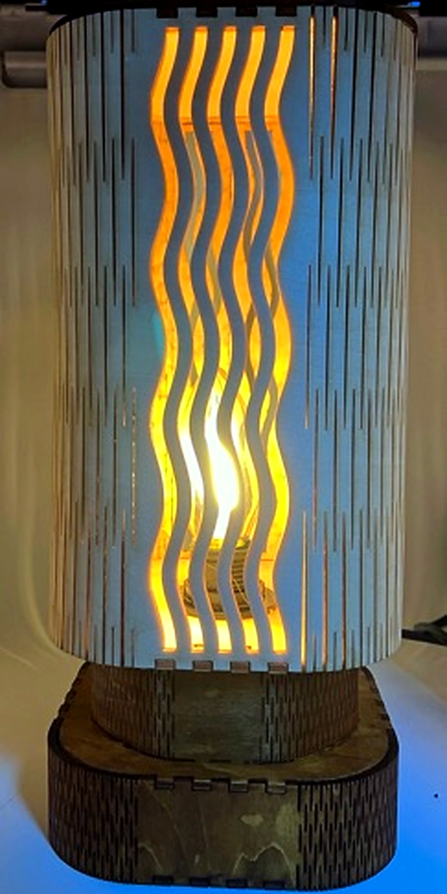 Référence LA 2a — lampe en bois aux lignes ondulées dans une pièce claire
